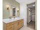 Modern bathroom vanity with marble countertop, stylish light fixtures, and walk-in closet access at 1784 Nw 85Th Loop, Ocala, FL 34475