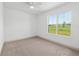 Bright and airy bedroom featuring large window with scenic views and neutral carpeting at 1784 Nw 85Th Loop, Ocala, FL 34475