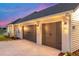 Exterior view of a home with a three-car garage, illuminated by outdoor lighting at dusk at 1784 Nw 85Th Loop, Ocala, FL 34475
