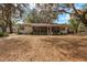 Back exterior of home featuring a screened-in porch and lush, mature landscaping at 18027 Se 90Th St, Ocklawaha, FL 32179