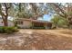 Back exterior showing property with beautiful mature landscaping and outdoor living space at 18027 Se 90Th St, Ocklawaha, FL 32179