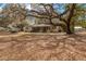 Backyard showcasing a home, mature trees, and leaves covering the ground at 18027 Se 90Th St, Ocklawaha, FL 32179