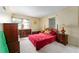 Bedroom with neutral carpet, two windows, and dark wood furniture at 18027 Se 90Th St, Ocklawaha, FL 32179