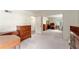 Open bedroom with neutral carpet, a sliding mirror closet door, and dark wood furnishings at 18027 Se 90Th St, Ocklawaha, FL 32179