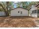 This exterior view shows the rear of an outbuilding on a well-maintained lot with lots of shade at 18027 Se 90Th St, Ocklawaha, FL 32179