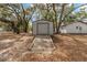 This exterior view shows a storage building and the rear of another building on a well-maintained lot with lots of shade at 18027 Se 90Th St, Ocklawaha, FL 32179