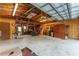 Spacious garage with exposed wood beams and concrete floor at 18027 Se 90Th St, Ocklawaha, FL 32179