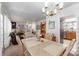 Open-concept living and dining area with chandelier lighting, hardwood floors, and lots of natural light at 18027 Se 90Th St, Ocklawaha, FL 32179