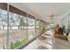 Screened porch with tile floor, furnishings, and backyard views at 18027 Se 90Th St, Ocklawaha, FL 32179