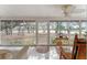 The screened porch features tile flooring, ceiling fan, furniture, and views of the yard at 18027 Se 90Th St, Ocklawaha, FL 32179