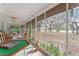 The screened porch features tile flooring, furnishings, a game table, and serene views of the surrounding nature at 18027 Se 90Th St, Ocklawaha, FL 32179