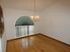 Bright dining area with hardwood floors, chandelier, and large arched window at 20364 Sw 86Th Loop, Dunnellon, FL 34431