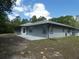 Home exterior featuring a screened porch and back patio, with backyard trees at 20364 Sw 86Th Loop, Dunnellon, FL 34431