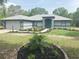 Charming single-story home with a beautifully landscaped front yard and a blue front door at 20364 Sw 86Th Loop, Dunnellon, FL 34431