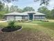 Charming single-story home with a beautifully landscaped front yard and a blue front door at 20364 Sw 86Th Loop, Dunnellon, FL 34431