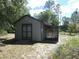 Wooden shed with double doors, a covered alcove, and surrounding trees at 20364 Sw 86Th Loop, Dunnellon, FL 34431