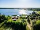 Overhead view of lakefront property featuring multiple buildings, private dock, and lush greenery at 23800 Ne 190Th St, Fort Mc Coy, FL 32134