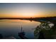 Stunning aerial view of a tranquil lake at sunset, showcasing lush trees and a cozy dock with a flag at 23800 Ne 190Th St, Fort Mc Coy, FL 32134