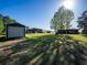 Expansive backyard featuring lush greenery, a serene pond, and several outbuildings for various activities at 23800 Ne 190Th St, Fort Mc Coy, FL 32134