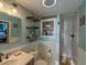Nicely decorated bathroom featuring a sink, open shelving, a toilet, and a partial view of the shower at 23800 Ne 190Th St, Fort Mc Coy, FL 32134