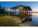 Charming boathouse featuring a covered deck with picnic tables, perfect for lakeside relaxation at 23800 Ne 190Th St, Fort Mc Coy, FL 32134