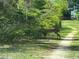 A deer stands amidst lush greenery, with a glimpse of a charming building in the background at 23800 Ne 190Th St, Fort Mc Coy, FL 32134