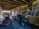 Garage featuring an ATV, lawn mower and trailer, offering space for vehicle and equipment storage at 23800 Ne 190Th St, Fort Mc Coy, FL 32134