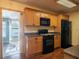 Functional kitchen area with black appliances and wooden cabinets at 23800 Ne 190Th St, Fort Mc Coy, FL 32134