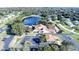 Aerial view of community buildings, roads, parking, and a lake surrounded by lush greenery at 28 Gordon Ct, Leesburg, FL 34788