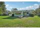 Backyard featuring an open green lawn and a view of the home's back exterior with awning-covered windows at 28 Gordon Ct, Leesburg, FL 34788