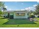 A spacious green lawn leads up to the back exterior of the home, which features an awning-covered window at 28 Gordon Ct, Leesburg, FL 34788