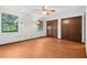 Bright bedroom with wood floors, two windows, and ample closet space at 28 Gordon Ct, Leesburg, FL 34788