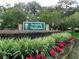 Manicured entrance to Scottish Highlands with a decorative sign surrounded by lush greenery and flowers at 28 Gordon Ct, Leesburg, FL 34788