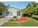 Charming single-story home with a well-manicured lawn, mature landscaping, and a cozy screened-in porch at 28 Gordon Ct, Leesburg, FL 34788