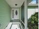 Inviting front porch featuring a decorative glass door, fresh paint, and lush greenery, offering a warm welcome at 28 Gordon Ct, Leesburg, FL 34788