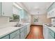 Bright kitchen with white counters, stainless steel sink, blue cabinets, and a view to the living room making meal prep enjoyable at 28 Gordon Ct, Leesburg, FL 34788