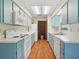 Charming kitchen features blue cabinets, white appliances, and ample counter space, perfect for culinary enthusiasts at 28 Gordon Ct, Leesburg, FL 34788