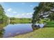 Scenic pond with serene waterside view under blue sky offering a tranquil landscape and enhancing natural surroundings at 28 Gordon Ct, Leesburg, FL 34788