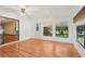 Bright sunroom featuring wood floors, three windows, and access to backyard offering a relaxing view to the outdoors at 28 Gordon Ct, Leesburg, FL 34788