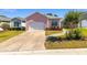 Lovely pink single-story home featuring an attached garage, concrete driveway, and well-kept front yard at 2935 Sw 41St Pl, Ocala, FL 34474