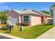 Charming single-story pink home with manicured lawn, white trim, and attached garage on a sunny day at 2935 Sw 41St Pl, Ocala, FL 34474