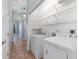 This laundry room features tile flooring, washer, dryer, and convenient shelfing at 2935 Sw 41St Pl, Ocala, FL 34474