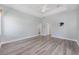 This primary bedroom features wood floors, a fan, and a door to an ensuite bathroom at 2935 Sw 41St Pl, Ocala, FL 34474