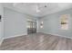 This primary bedroom features wood floors, a fan, large sliding doors, and two windows at 2935 Sw 41St Pl, Ocala, FL 34474