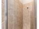 A walk-in shower featuring neutral tile walls and glass doors at 2935 Sw 41St Pl, Ocala, FL 34474