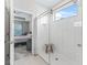 Modern bathroom featuring a glass-enclosed shower with white tile and a wooden stool at 3840 Se 6Th Ave, Ocala, FL 34480