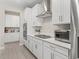 The open kitchen has stainless steel appliances and a gas cooktop with modern white cabinets at 3840 Se 6Th Ave, Ocala, FL 34480