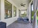 Comfortable screened lanai with stylish seating, a ceiling fan, and tranquil views of the meticulously landscaped backyard at 3840 Se 6Th Ave, Ocala, FL 34480