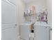 Functional laundry room with modern washer and dryer, complemented by shelving for storage of cleaning supplies at 3840 Se 6Th Ave, Ocala, FL 34480