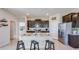 Open kitchen featuring dark cabinets, a granite countertop island with seating, and stainless steel appliances at 4050 Nw 48Th Terrace Rd, Ocala, FL 34482
